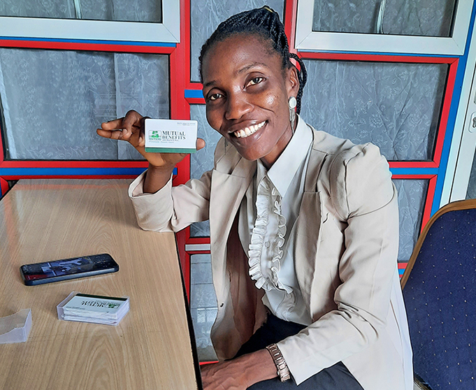 Mutual Benefits staff, Mrs Okotie Onome Ogbotor holding business cards designed and printed by Simtech Creative for Mutual Benefits Assurance Plc - Warri, Nigeria